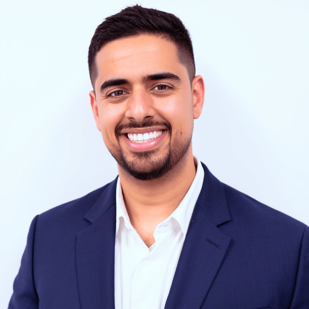 Mark Kashef headshot in a navy blazer and open white shirt, smiling